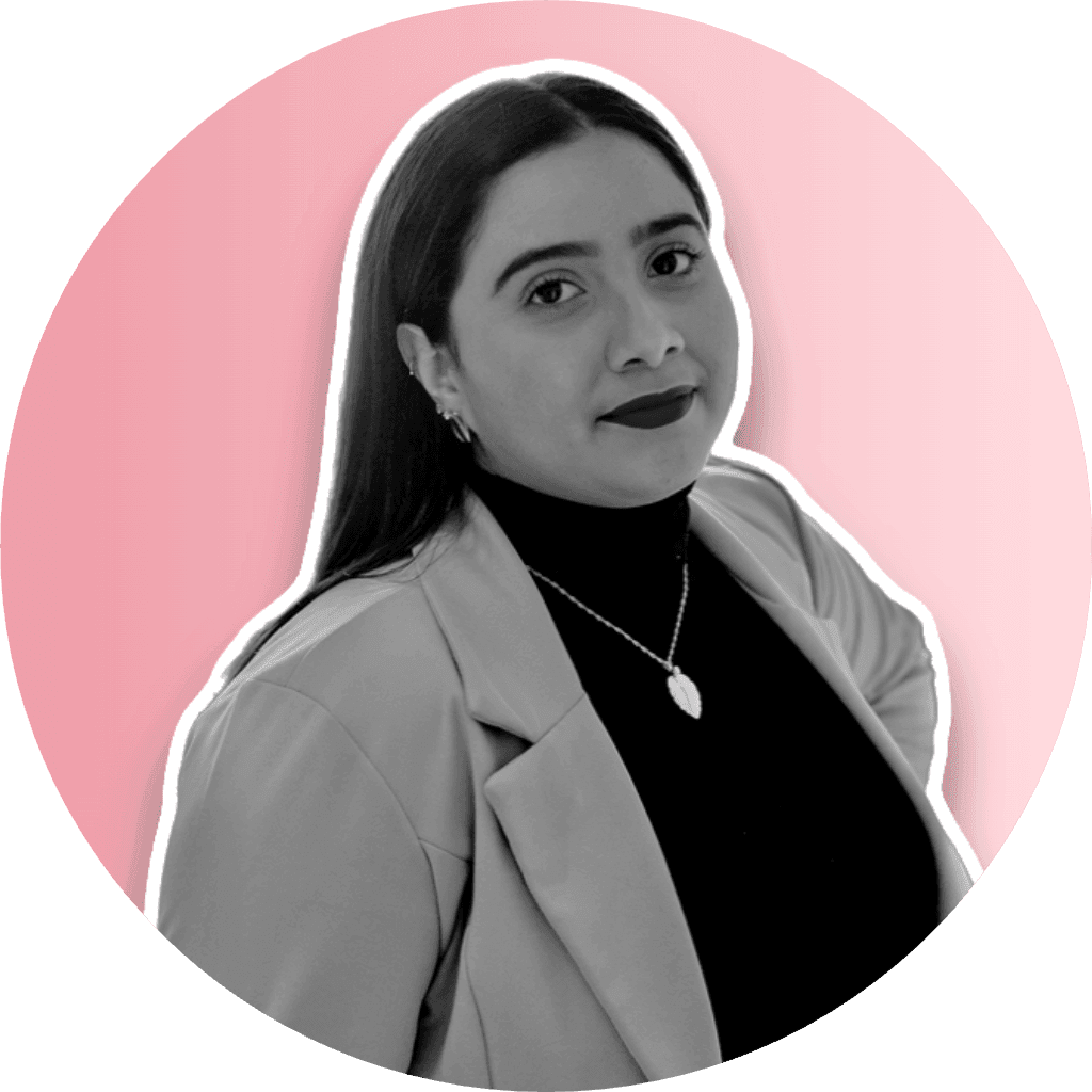 Black and white portrait of a woman in a blazer on a pink background.