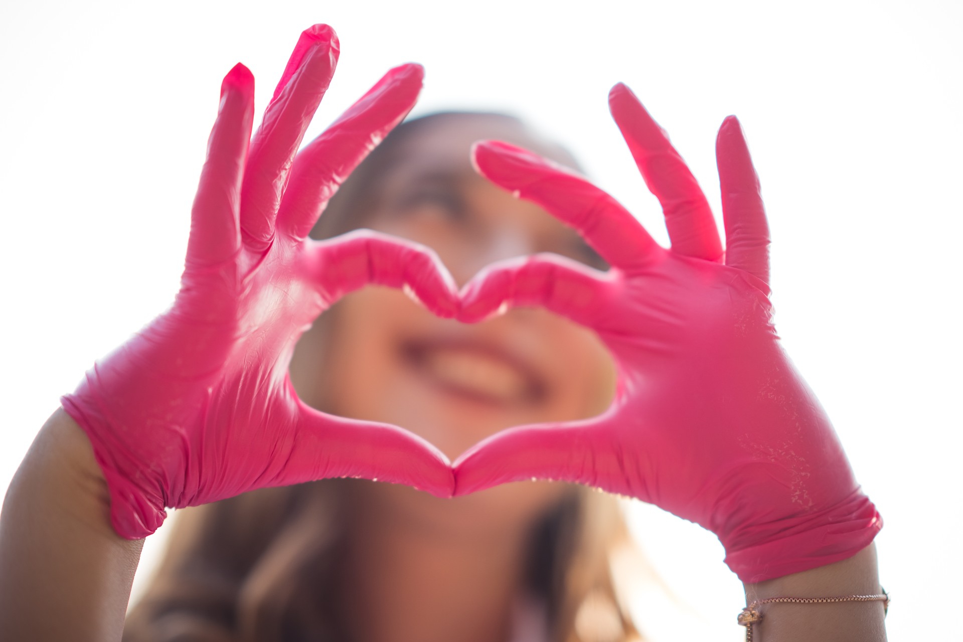 Doctor hands in gloves making shape of heart